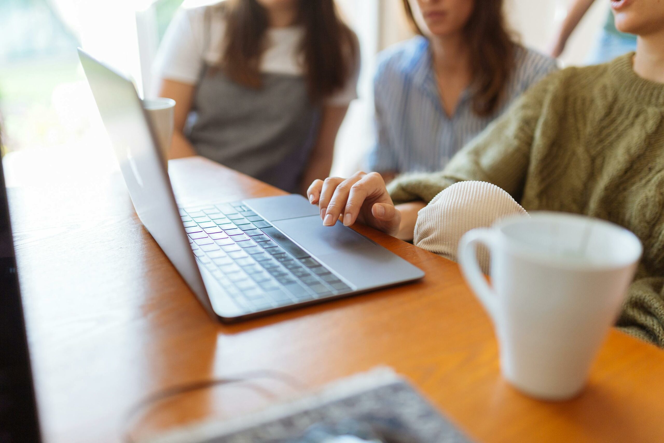 What are the 5 W's to Cover in the Press Release Opening Paragraph 2 Three people sat around a desk opening a laptop