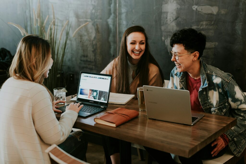 Contact us - three people sat around the desk laughing