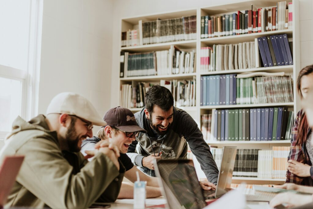 PR Fire Pay-as-you-go Services | A group of people sat around a desk laughing at a computer