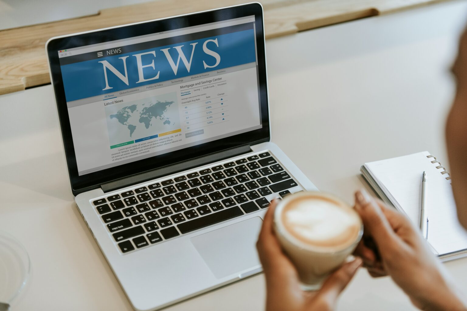 A person drinking coffee while looking at their business news.